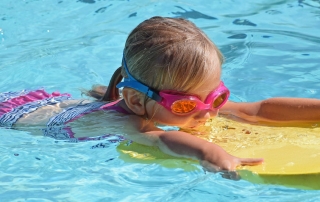 Girl on Bodyboard in Swimming Pool