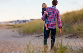 Man Walking with Child on Beach